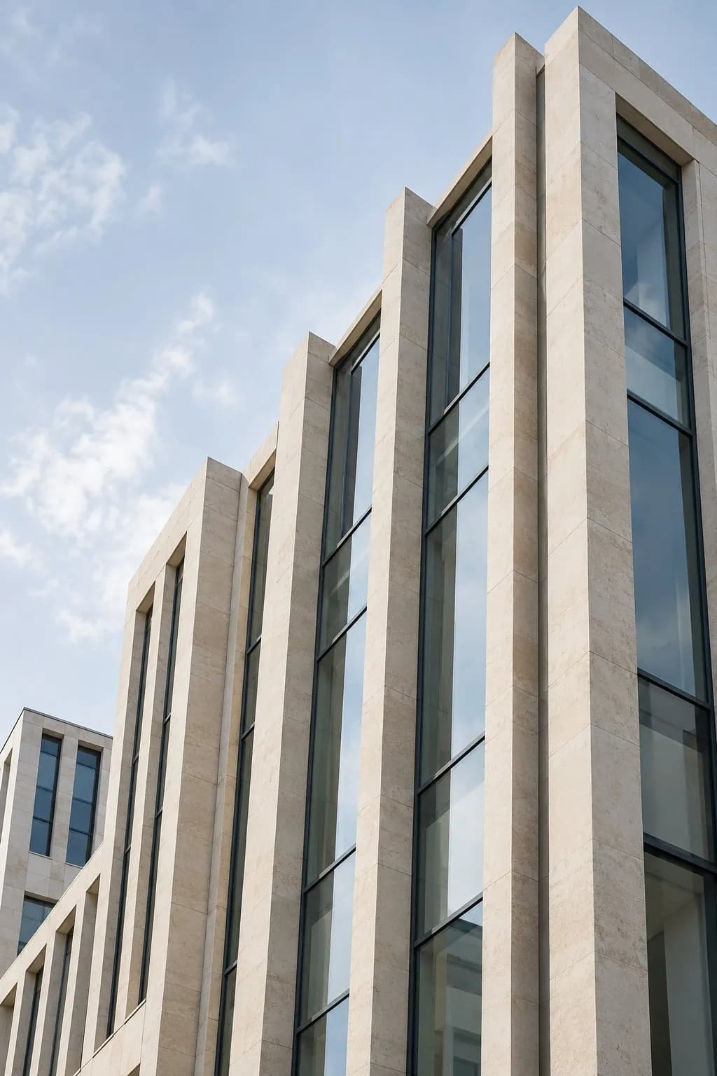 Fachada de un edificio con ventanales verticales. Imagen conceptual generada por IA; no es la sede del despacho.